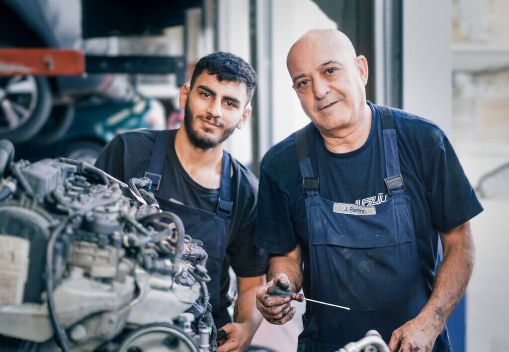 Zwei Mechaniker des Autohaus Freier bei der Motorreparatur in der Meisterwerkstatt in Heilbronn